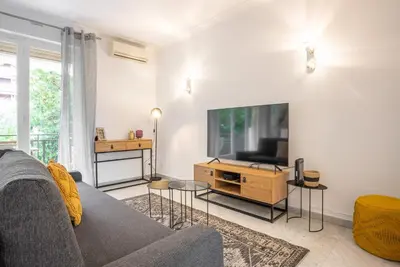 a living room with a couch and a flat screen tv at Le Smile by Winsome Destination in Cannes