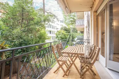 a balcony with a wooden table and chairs on it at Le Smile by Winsome Destination in Cannes