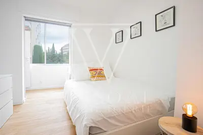 a white bedroom with a bed and a window at Le Smile by Winsome Destination in Cannes