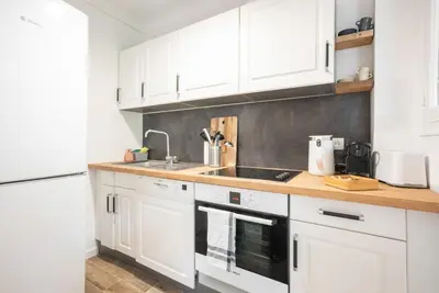 a kitchen with white cabinets and a sink at Le Smile by Winsome Destination in Cannes