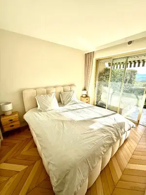 a white bed in a bedroom with a large window at Garden sea view - Victoria - Le Cannet in Le Cannet
