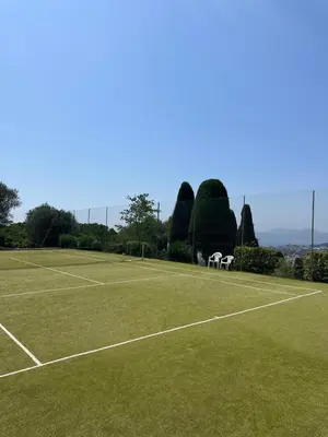 a tennis court with two white chairs on it at Garden sea view - Victoria - Le Cannet in Le Cannet