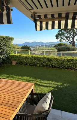 a patio with a table and a chair with a view of the water at Garden sea view - Victoria - Le Cannet in Le Cannet