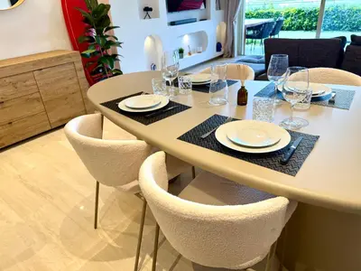 a dining room table with chairs and plates and wine glasses at Garden sea view - Victoria - Le Cannet in Le Cannet