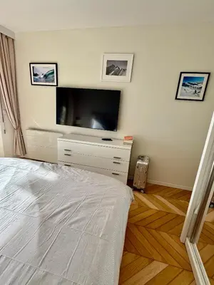 a bedroom with a bed and a flat screen tv at Garden sea view - Victoria - Le Cannet in Le Cannet