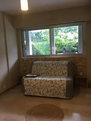 a couch in a living room with a window at Studette de Cannes in Cannes