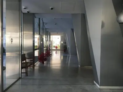 a hallway of a building with glass doors and a chair at Studette de Cannes in Cannes