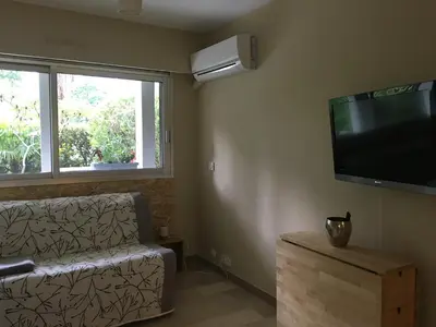 a living room with a couch and a flat screen tv at Studette de Cannes in Cannes
