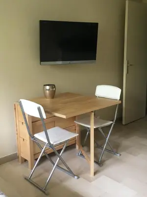 a desk with two chairs and a television on a wall at Studette de Cannes in Cannes