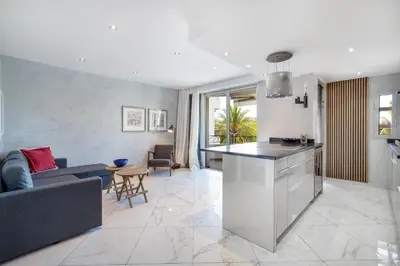 a kitchen and living room with a couch and a table at CROISETTE - 2 Pièces rénové avec vue Mer in Cannes