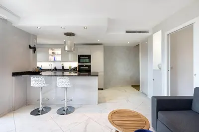 a kitchen and living room with a counter and stools at CROISETTE - 2 Pièces rénové avec vue Mer in Cannes