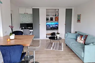 a living room with a blue couch and a table at HENRI CAMILLE RE - Passy 2 -Beautiful one bedroom swimming pool and parking in Cannes