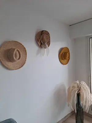 three hats are hanging on a white wall at HENRI CAMILLE RE - Passy 2 -Beautiful one bedroom swimming pool and parking in Cannes