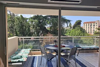 a balcony with a table and chairs and a view at HENRI CAMILLE RE - Passy 2 -Beautiful one bedroom swimming pool and parking in Cannes