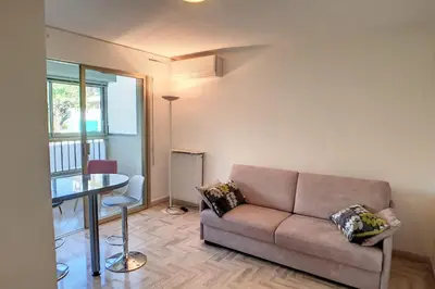 a living room with a couch and a table at HENRI CAMILLE REAL ESTATE - Latour - Studio 150m Martinez in Cannes