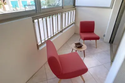 a room with two chairs and a red chair and a table at HENRI CAMILLE REAL ESTATE - Latour - Studio 150m Martinez in Cannes