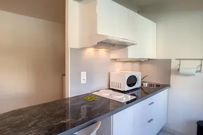 a kitchen with a counter top with a microwave at HENRI CAMILLE REAL ESTATE - Latour - Studio 150m Martinez in Cannes