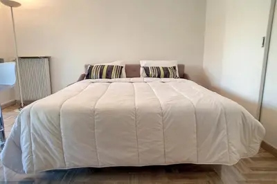 a white bed with two pillows in a bedroom at HENRI CAMILLE REAL ESTATE - Latour - Studio 150m Martinez in Cannes