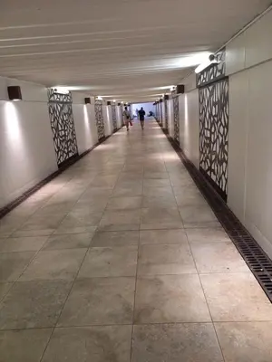 a long hallway in a building with people walking down it at Le St Nicolas in Cannes