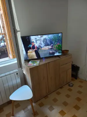 a flat screen tv sitting on top of a wooden cabinet at Le St Nicolas in Cannes