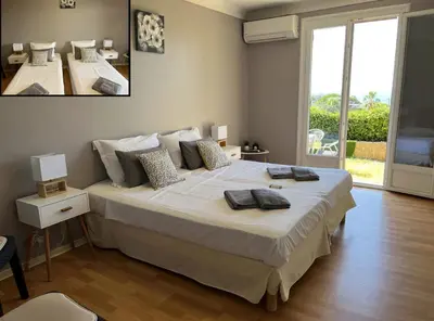 a bedroom with a large bed and a large window at Charming Villa-Appartement With A View On The Sea Of 95 M2 in Cannes