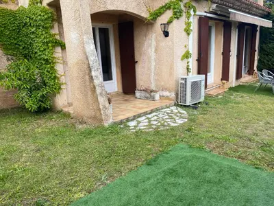 a house with a yard with a air conditioner at Charming Villa-Appartement With A View On The Sea Of 95 M2 in Cannes