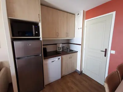 a small kitchen with a refrigerator and a microwave at Cannes Villa Francia appartement 7 personnes climatisé in Cannes