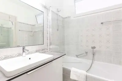 a white bathroom with a sink and a bath tub at Florida 35m studio with sea views close to the Croisette in Cannes