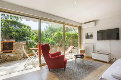 a living room with a red chair and a large window at Studio A/C La Californie with patio by Olidesi in Cannes