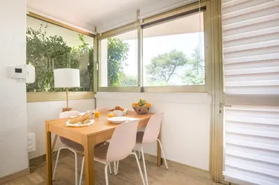 a dining room with a table and chairs and a window at Studio A/C La Californie with patio by Olidesi in Cannes