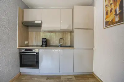 a kitchen with white cabinets and a sink at Studio A/C La Californie with patio by Olidesi in Cannes