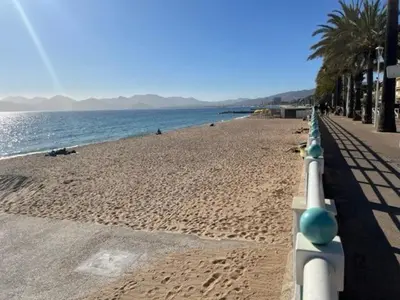 a beach with a white fence and the ocean at Fantastic located studio in Cannes