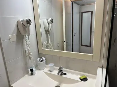 a bathroom with a sink with a hair dryer and a mirror at Fantastic located studio in Cannes
