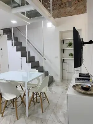a white room with a table and chairs and a staircase at Sunflower apartments in Cannes