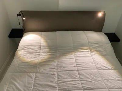 a white bed in a bedroom with lights on it at Sunflower apartments in Cannes