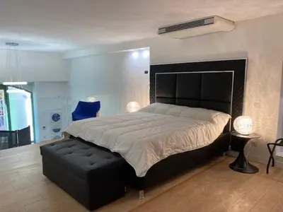 a bedroom with a large bed and a blue chair at Sunflower apartments in Cannes