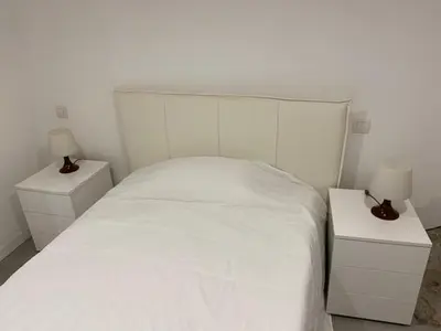 a bedroom with a white bed with two night stands at Sunflower apartments in Cannes