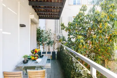 a living room with a leather couch and a table at Le Cocon des Artistes - Coeur de Cannes - Spacieux - Terrasse - Clim in Cannes
