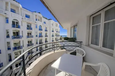 a balcony with a table and chairs and a building at Palais des Iles in Cannes