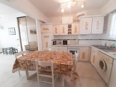a kitchen with a table with chairs and a kitchen with white cabinets at Palais des Iles in Cannes