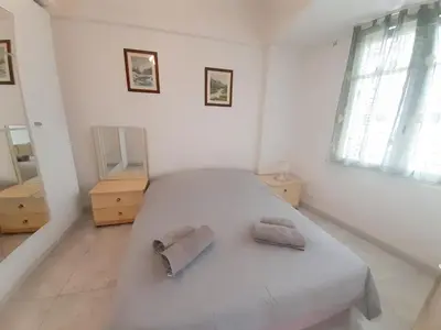 a white bedroom with a bed with two towels on it at Palais des Iles in Cannes