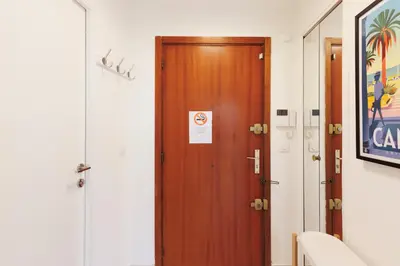 a wooden door in a hallway with a sign on it at Bleu Croisette YourHostHelper in Cannes