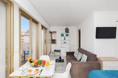 a living room with a table and a couch at Bleu Croisette YourHostHelper in Cannes