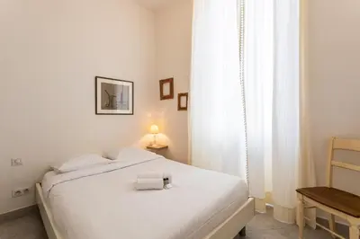 a white bedroom with a bed with a towel on it at Freres PradignacLAT1101 in Cannes