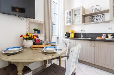 a kitchen with a wooden table and chairs in a kitchen at Freres PradignacLAT1101 in Cannes