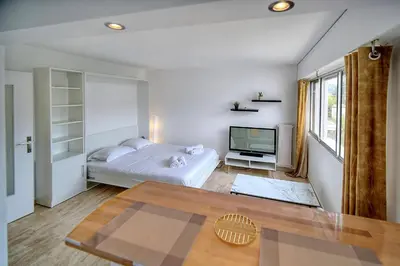 a white bedroom with a bed and a television at IMMOGROOM - Cosy - California - Close to everything in Cannes