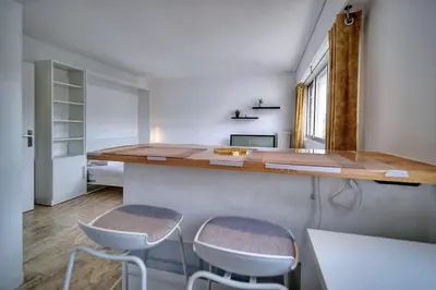 a kitchen with two stools at a counter with a counter top at IMMOGROOM - Cosy - California - Close to everything in Cannes