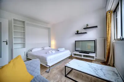 a living room with a bed and a tv at IMMOGROOM - Cosy - California - Close to everything in Cannes