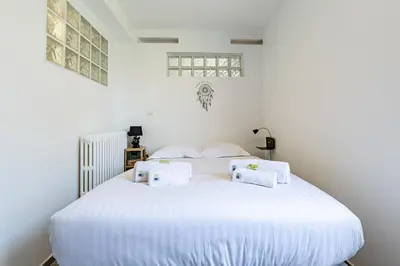 a bedroom with a white bed with towels on it at IMMOGROOM - Renovated - Terrace - Air conditioning - Quiet - Carnot in Cannes