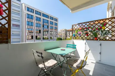 a table and chairs on a balcony with a building at IMMOGROOM - Renovated - Terrace - Air conditioning - Quiet - Carnot in Cannes